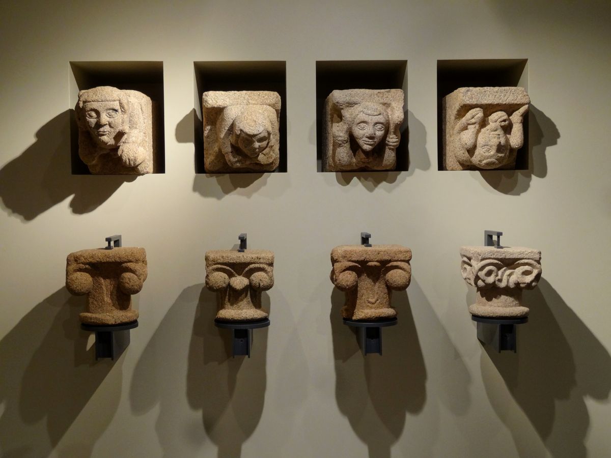 Sculptures et chapiteaux déplacés. 4 visages dans 4 niches au dessus de 4 chapiteaux. Ombres et lumières multiples.