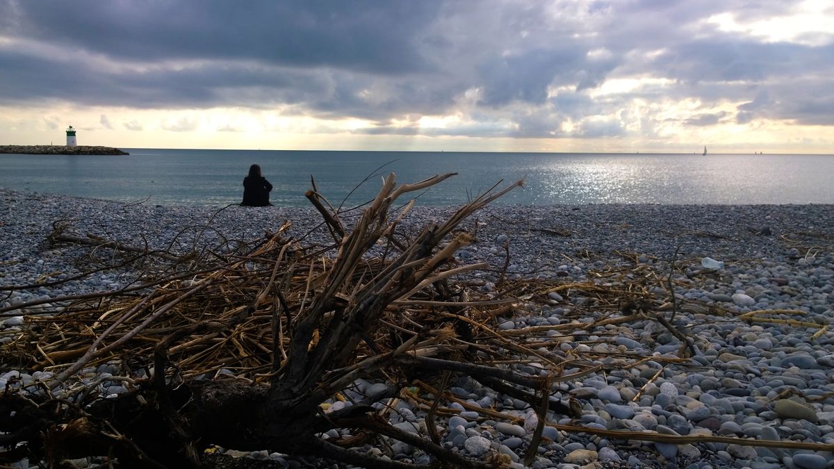 Thinking: a gravels beach, the lighthouse, the sea and the sails, in a winter afternoon, and a woman looking far away