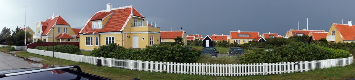 Old town Skagen in Northern Denmark, with their distinctive gold coloured houses, red brick roofs and white chimneys.