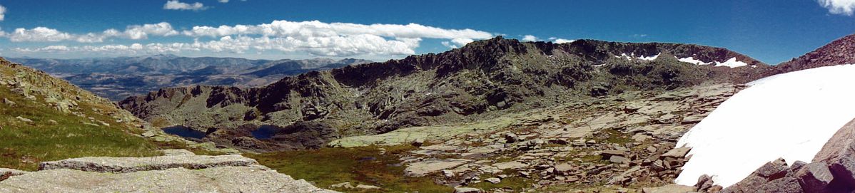 Lagunas Glaciares y nacimiento de un arroyo de un nevero. Agosto. Gredos